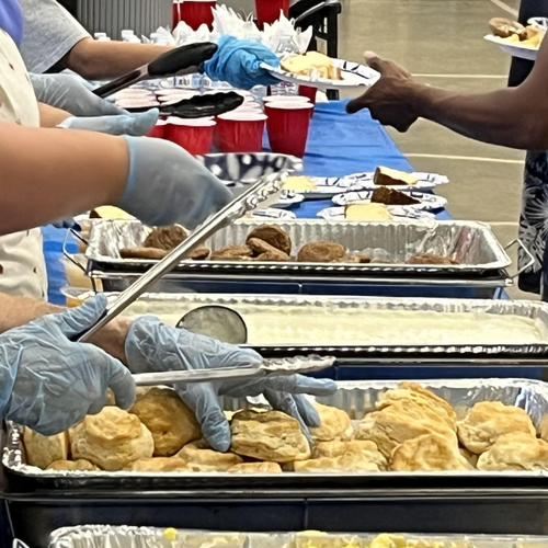 Members of the temple serving food to men at the shelter.
