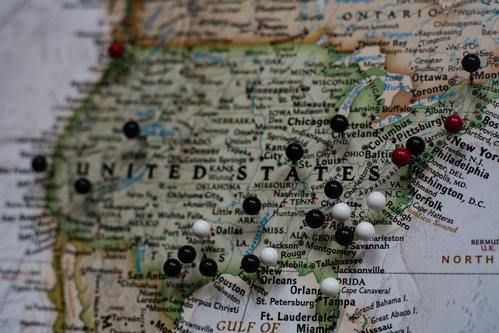 Map of United States of America with black and white pins throughout the map.